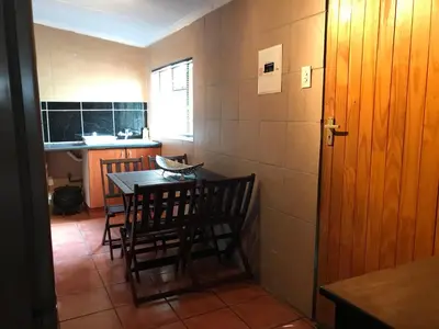 a kitchen with a table and chairs in a room at Contemporary Stay at Giraffe Cottage in Benoni