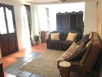 a living room with a couch and a table at Contemporary Stay at Giraffe Cottage in Benoni