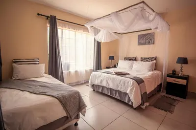 a bedroom with two beds and a canopy bed at 515 on Warthog by the River in Marloth Park