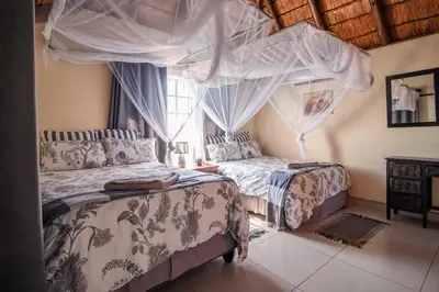 a bedroom with two beds and a window at 515 on Warthog by the River in Marloth Park