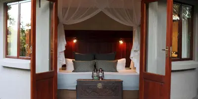 a bedroom with a bed with a canopy at Ivory Wilderness River Rock Lodge in Klaserie Private Nature Reserve