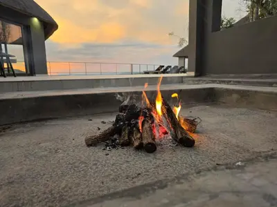 a fire burns in the sand next to a building at Bona Kgole Private Game Lodge, Mabalingwe in Warmbaths