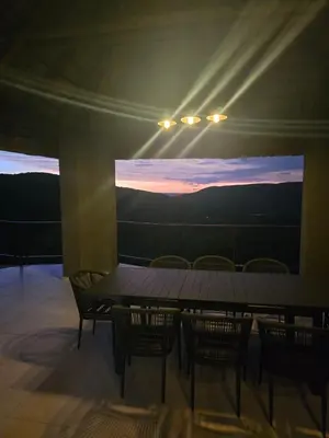 a table and chairs in a room with a large screen at Bona Kgole Private Game Lodge, Mabalingwe in Warmbaths