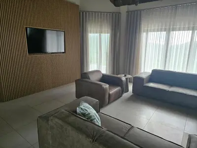 a living room with a couch and a tv at Bona Kgole Private Game Lodge, Mabalingwe in Warmbaths
