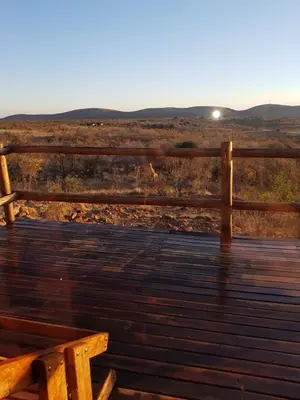 a wooden bench sitting on top of a wooden deck at Lodge Twentyfour Mabalingwe Nature Reserve in Warmbaths