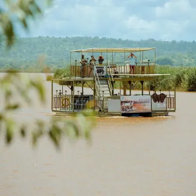 a boat on a river with people on the deck at Sefapane Lodge and Safaris in Phalaborwa