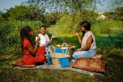 a group of three people sitting around a picnic blanket at Sefapane Lodge and Safaris in Phalaborwa