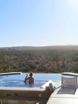 a man in a swimming pool with a view at Tebuah Private Lodge, Mabalingwe in Mabula