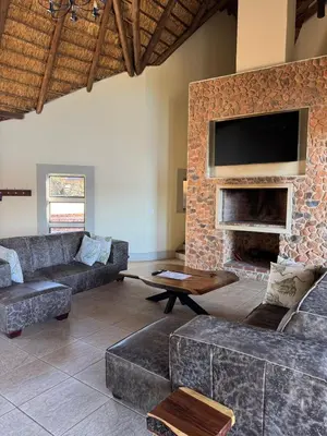 a living room with a couch and a fireplace at Tebuah Private Lodge, Mabalingwe in Mabula