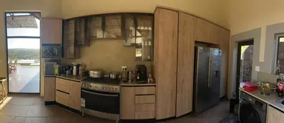 a kitchen with wooden cabinets and a stove at Tebuah Private Lodge, Mabalingwe in Mabula
