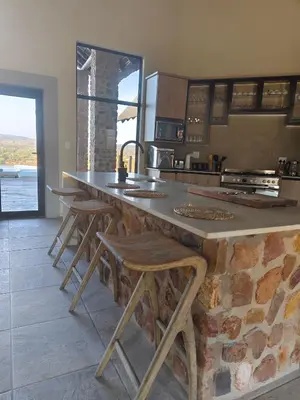 a kitchen with a large counter with stools in it at Tebuah Private Lodge, Mabalingwe in Mabula