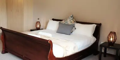 a bed in a room with two lamps on tables at Goedehoop Boutique Manor House in Malelane