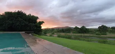 a view of the sunset from the backyard of a house at Goedehoop Boutique Manor House in Malelane