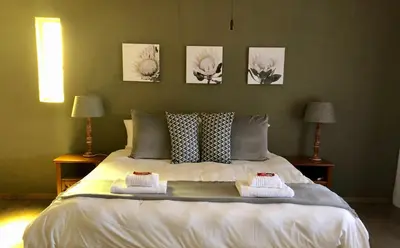 a bedroom with a bed with two towels on it at Summerplace Holiday Home in Hazyview