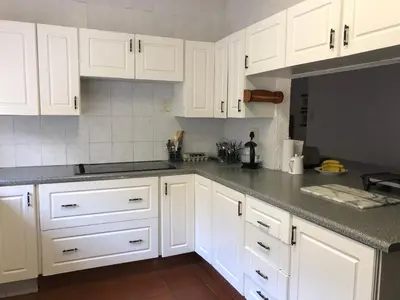 a kitchen with white cabinets and gray counter tops at Summerplace Holiday Home in Hazyview