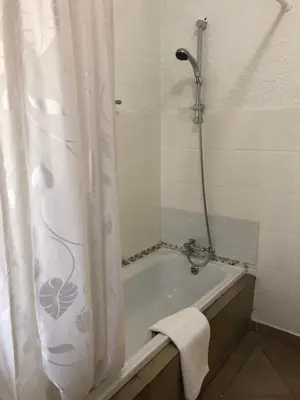 a bathroom with a bath tub with a shower curtain at Summerplace Holiday Home in Hazyview