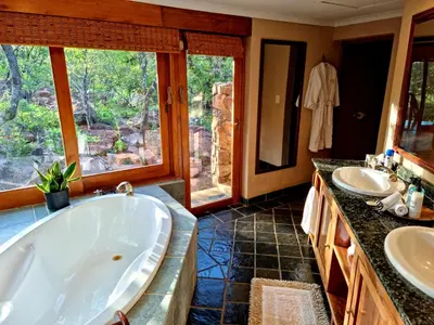 a large bathroom with two sinks and a tub at Sekala Private Game Lodge in Welgevonden Game Reserve