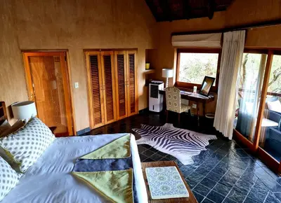 a room with a bed and a desk with a computer at Sekala Private Game Lodge in Welgevonden Game Reserve