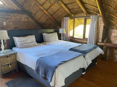 a bedroom with a large bed in a room at Crocriver Chalet Schoemanskloof in Schoemanskloof