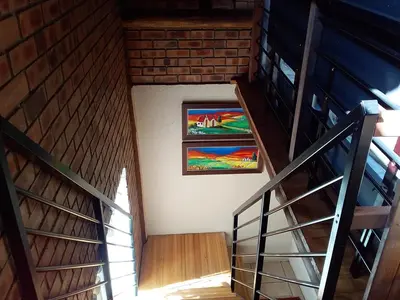 an attic stairway with two pictures on the wall at Crocriver Chalet Schoemanskloof in Schoemanskloof
