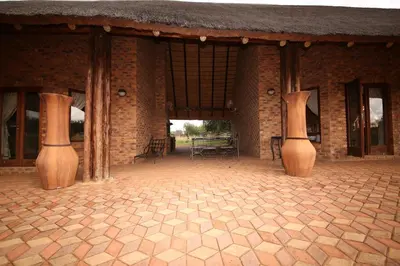 a brick building with vases in the middle of a patio at Makhato Bush Lodge 109 in Bela-Bela