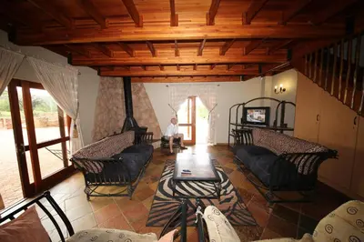 a man sitting in a room with chairs and a table at Makhato Bush Lodge 109 in Bela-Bela