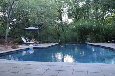 a swimming pool with an umbrella and a ball in it at Angel Oak guesthouse in Brits