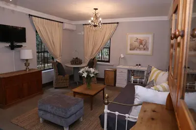 a living room with a couch and a chair at Angel Oak guesthouse in Brits