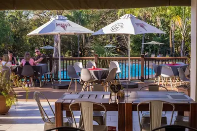 a patio with tables and chairs and umbrellas at Kruger Park Lodge Unit No. 612 in Hazyview