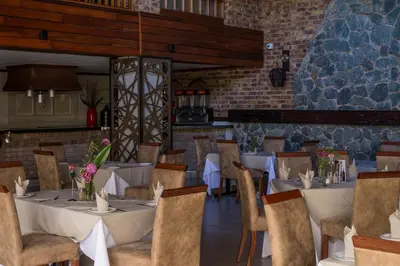 a restaurant with tables and chairs and a brick wall at Kruger Park Lodge Unit No. 612 in Hazyview