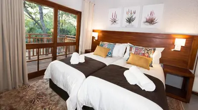 a bedroom with a large bed and a balcony at Kruger Park Lodge Unit No. 612 in Hazyview