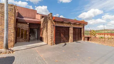 a brick building with two large doors on it at See You There Accommodation 2 in Centurion