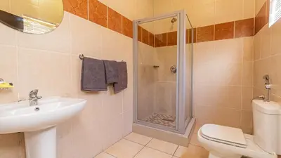 a bathroom with a shower and a toilet and a sink at See You There Accommodation 2 in Centurion
