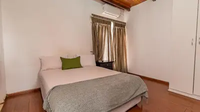 a bedroom with a white bed with a green pillow at See You There Accommodation 2 in Centurion