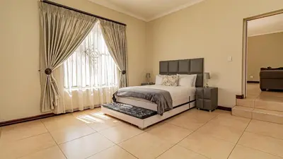 a bedroom with a bed and a large window at See You There Accommodation 1 in Centurion