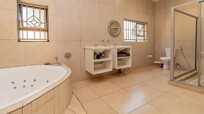 a bathroom with a tub and a sink and a toilet at See You There Accommodation 1 in Centurion