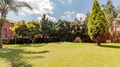 a yard with a tree and a wooden structure at See You There Accommodation 1 in Centurion