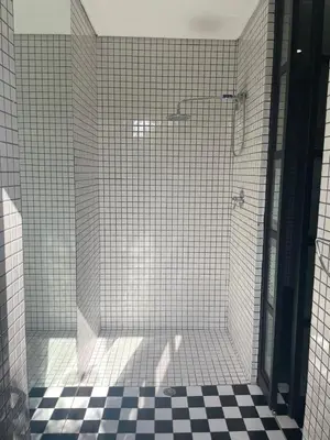 a bathroom with a shower with black and white tiles at See You There Accommodation in Centurion