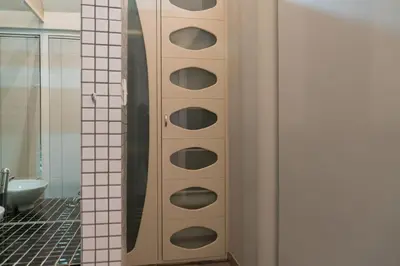 a bathroom with a cabinet with circles in the wall at See You There Accommodation in Centurion