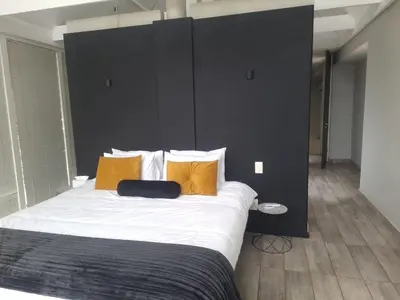 a bedroom with a large bed with yellow pillows at See You There Accommodation in Centurion