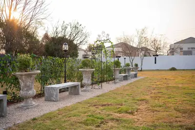 a row of benches in a park with a fence at See You There Accommodation in Centurion
