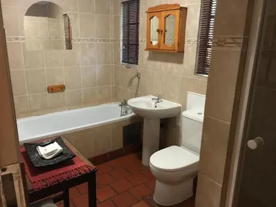 a bathroom with a toilet and a sink and a tub at De Oude Herberg in Centurion