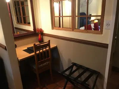 a room with a table and a chair and two mirrors at De Oude Herberg in Centurion