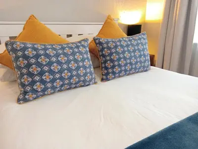 a bed with two blue pillows on top of it at Willows Garden Studio in Pretoria