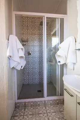 a bathroom with a shower and a sink and towels at Willows Garden Studio in Pretoria