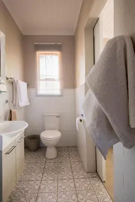 a bathroom with a toilet and a sink at Willows Garden Studio in Pretoria