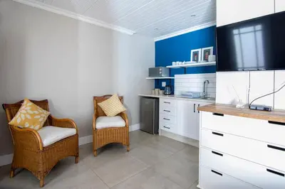 a kitchen with a tv and two chairs in a room at Willows Garden Studio in Pretoria