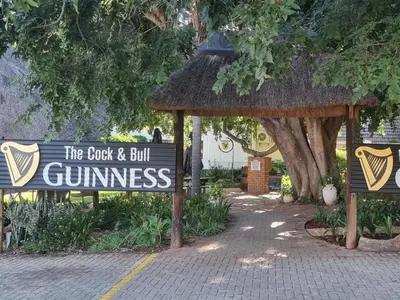 a sign for the golf and but gimmeennes in a park at Cock & Bull Restaurant - Pub - Accommodation in Hartbeespoort
