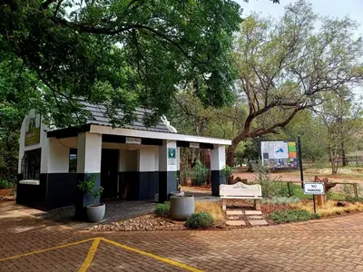 a building with a bench in a park at Cock & Bull Restaurant - Pub - Accommodation in Hartbeespoort