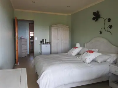 a bedroom with a large white bed with white pillows at Marula Cottage Guest Lodge in Thabazimbi